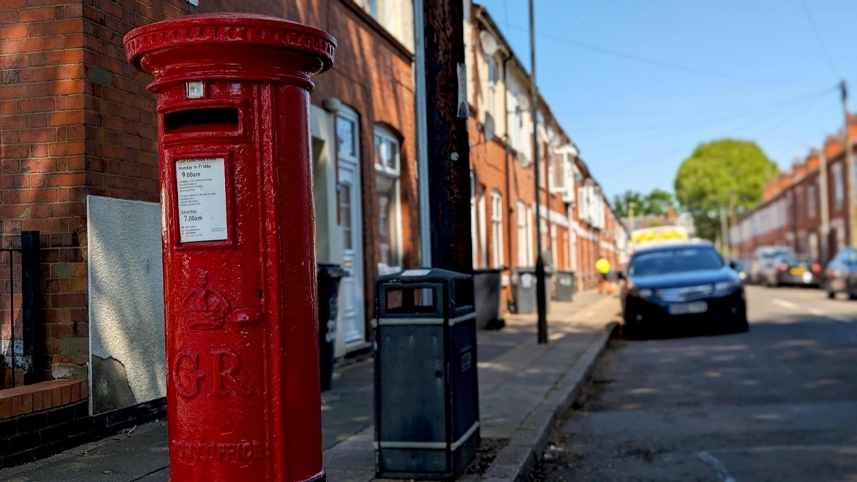 A red pillar box on a terraced street