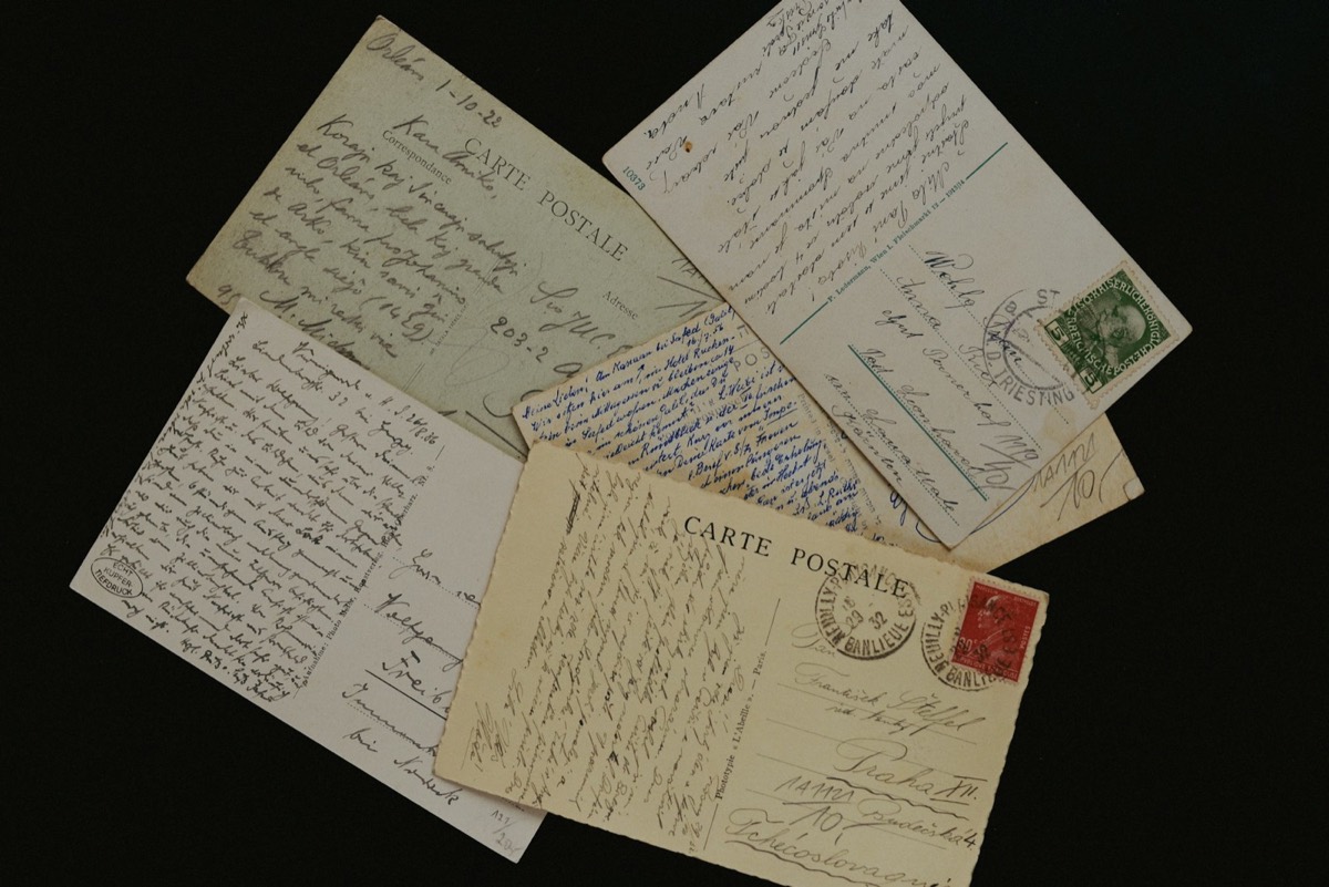 Old postcards and letters spread on a dark table